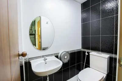 a bathroom with a toilet and a sink and a mirror at Restiny Hostel in Bangkok