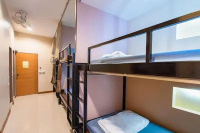 a room with three bunk beds and a hallway at Restiny Hostel in Bangkok