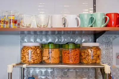 a refrigerator shelf filled with jars of food at Restiny Hostel in Bangkok