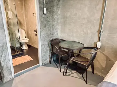 a table and chairs in a bathroom with a toilet at Sukhum Victorymonument-Ari in Bangkok