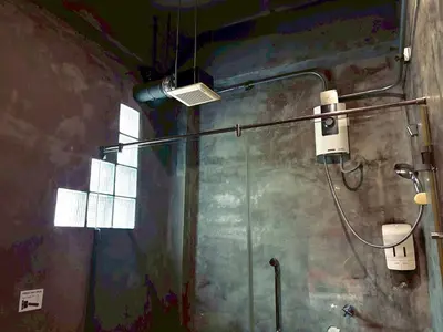 a bathroom with a shower with a light on the wall at Sukhum Victorymonument-Ari in Bangkok
