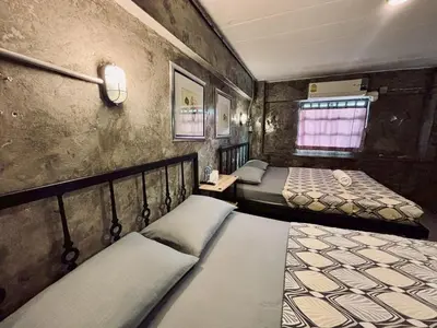 a bedroom with two beds and a window in it at Sukhum Victorymonument-Ari in Bangkok