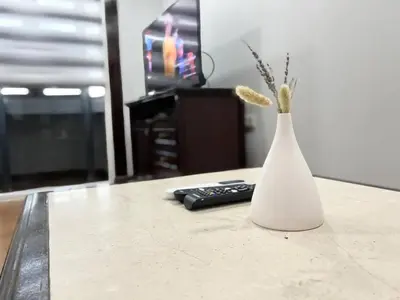 a white vase on a table with a remote control at Sukhumvit soi 4 Apartment Center of BKK in Bangkok