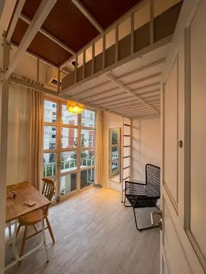 a living room with a table and a chair at TWH Hostel Bangkok in Bangkok