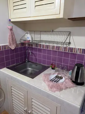 a kitchen counter with a sink and purple tiles at Ally home 14 06 in Thung Si Kan