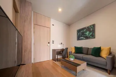 a living room with a couch and a table at Urban Oasis BTS Ekkamai in Khlong Toei