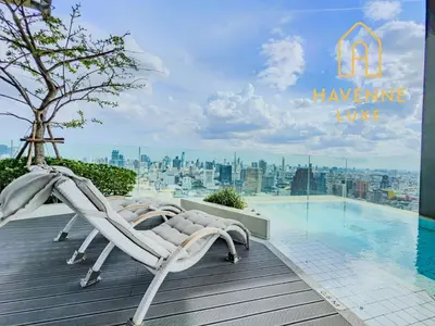 a couple of lounge chairs sitting on a deck next to a swimming pool at New City Condo in Central Bangkok in Pratunam