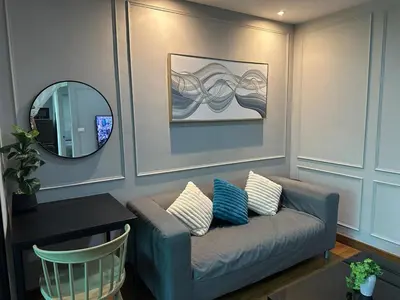 a living room with a couch and a mirror at Cozy Room - On Nut - Wi-Fi, Gym, Pool in Bangkok
