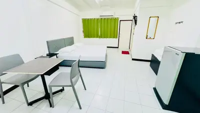 a room with a table and chairs and a couch at Bangkok-Pratunam Hotel in Bangkok