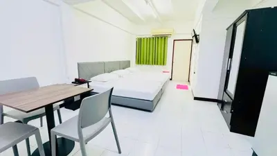 a living room with a bed and a table and chairs at Bangkok-Pratunam Hotel in Bangkok