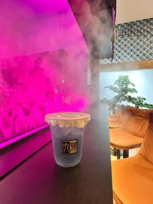 a cup of coffee on a table with pink lighting at Chinatown No9 Boutique Hotel in Bangkok
