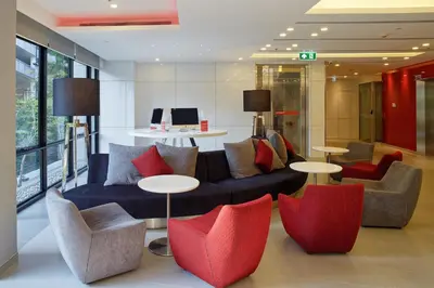 a living room with a couch and chairs and tables at Easy Planet Bangkok Surawong in Bangkok