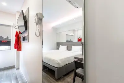 a bedroom with a bed and a mirror at Easy Planet Bangkok Surawong in Bangkok