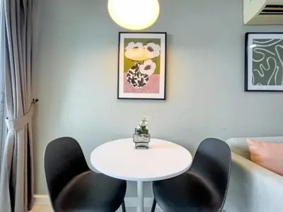 a white table and black chairs in a room at Near BTS l Fully Furnished l Pool and Gym in Bangkok