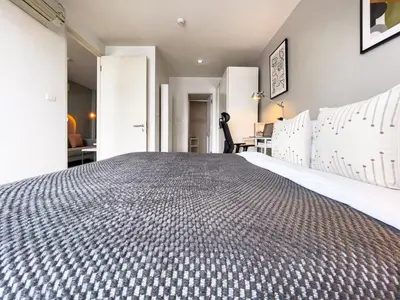 a bedroom with a large bed and a desk at Near BTS l Fully Furnished l Pool and Gym in Bangkok