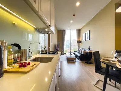 a kitchen and living room with a counter top and a sink at Near BTS l Large 50 sqm l Luxury facilities l Rooftop Pool in Bangkok
