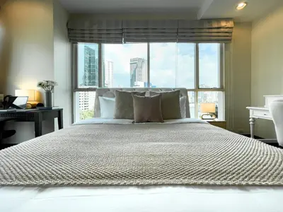 a bedroom with a large bed with a large window at 300m BTS l Large 110 sqm l Pool and Sauna in Bangkok