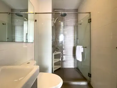 a bathroom with a shower and a toilet and a sink at Near BTS l Central Sukhumvit l Pool and Sauna in Bangkok