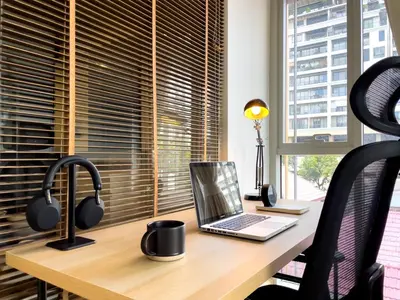 a desk with a laptop computer and headphones at Near BTS Asok and MRT SKV l Pool and Sauna in Bangkok