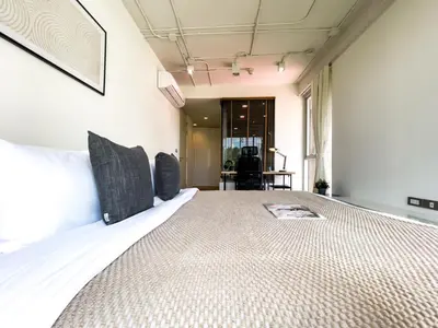 a bedroom with a large bed in a room at Near BTS Asok and MRT SKV l Pool and Sauna in Bangkok