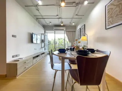 a dining room with a wooden table and chairs at Near BTS Asok and MRT SKV l Pool and Sauna in Bangkok