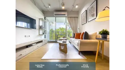 a living room with a couch and a tv at Near BTS Asok and MRT SKV l Pool and Sauna in Bangkok