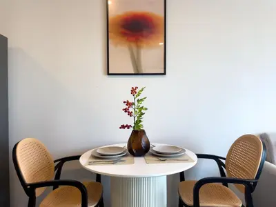 a table with a vase on it with chairs at 600 m to BTS l City View l Rooftop Pool in Bangkok