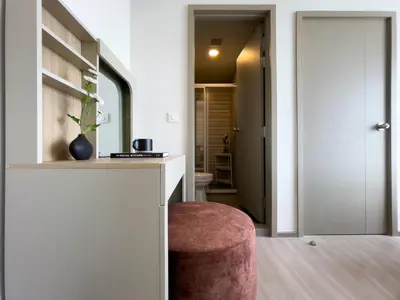 a living room with a pink stool and a hallway at 600 m to BTS l City View l Rooftop Pool in Bangkok