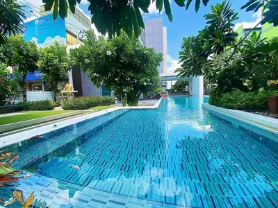 a swimming pool with blue water in a building at Minimal Condo At Ramkhamhaeng 64 in Sathani Ban Hua Mak
