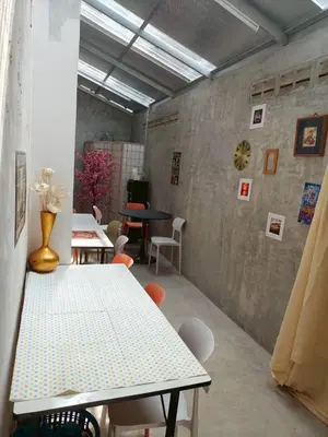a room with a table and chairs in a room at Bangkhunnon Station Hostel in Sathani Thon Buri