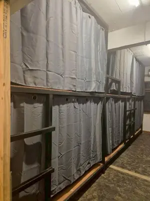 a room with two shelves filled with gray sheets at Bangkhunnon Station Hostel in Sathani Thon Buri