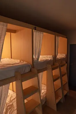 a room with three bunk beds in a room at Greet Hostel & Cafe Samyan in Bangkok