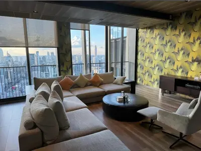 a living room with a large couch and a tv at Noble Bangkok Condo in Bangkok