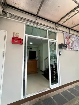 an open glass door of a building with a television at City View Condo 5 mins to MRT Sutthisarn in Bangkok