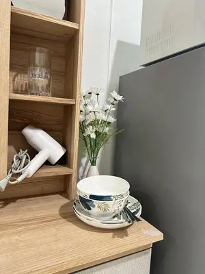 a cabinet with a bowl and a vase of flowers at City View Condo 5 mins to MRT Sutthisarn in Bangkok