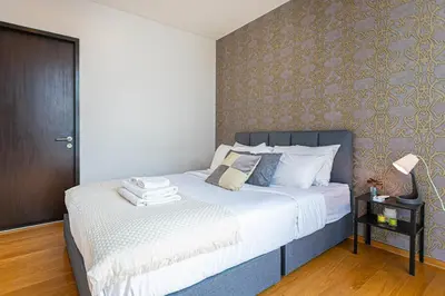 a bedroom with a large bed with white sheets at Warm&Cozy Stay near BTS Thonglor in Bangkok