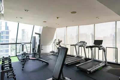 a gym with several tread machines in a building at Warm&Cozy Stay near BTS Thonglor in Bangkok