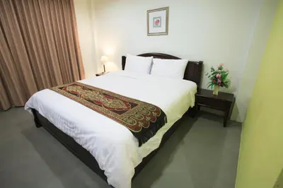 a bedroom with a large bed with white sheets and pillows at SU 22 in Bangkok
