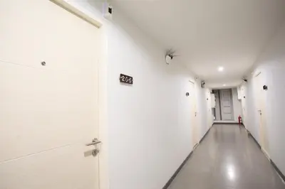 an empty hallway with white walls and a long hallway at SU 22 in Bangkok