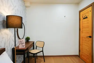 a bedroom with a desk and a lamp and a chair at Deluxe Gam-Hom Hostel เจริญนคร in Bangkok