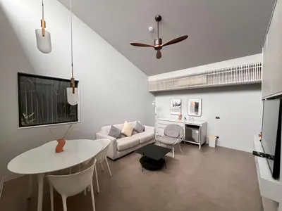 a living room with a couch and a table at Tree Villa Bangkok in Bangkok