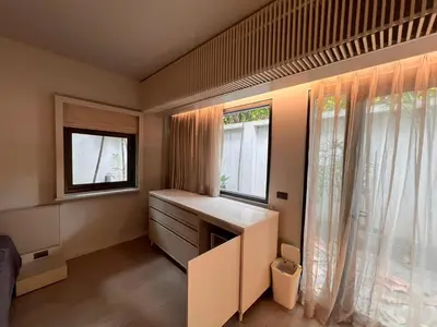 a small room with a desk and two windows at Tree Villa Bangkok in Bangkok