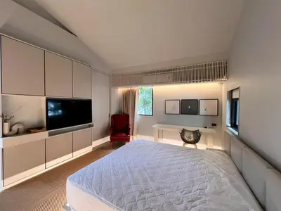a bedroom with a large bed and a television at Tree Villa Bangkok in Bangkok