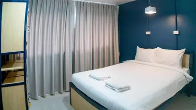 a bedroom with a large white bed with white pillows at LCT Hostel Bangkok in Bangkok