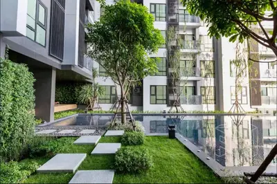 a garden in front of a building with a swimming pool at Thonglor Next to BTS Condominium in Bangkok