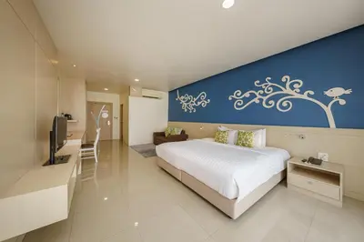 a bedroom with a large bed and a blue wall at Aspira Petchkasem in Ban Khlong Om Noi