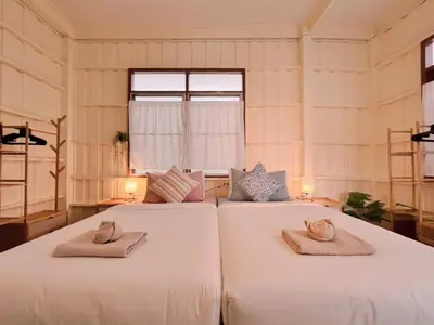 two white beds in a room with a window at Rare Find 80 yrs Heritage Peaceful House in BKK in Bangkok Yai