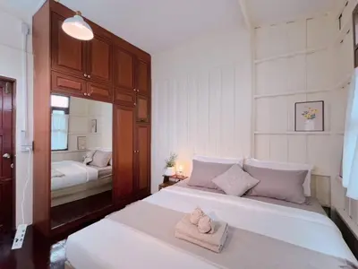 a bedroom with two beds with towels on them at Rare Find 80 yrs Heritage Peaceful House in BKK in Bangkok Yai