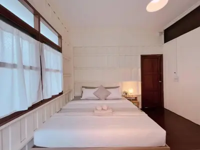a bedroom with a bed with a towel on it at Rare Find 80 yrs Heritage Peaceful House in BKK in Bangkok Yai