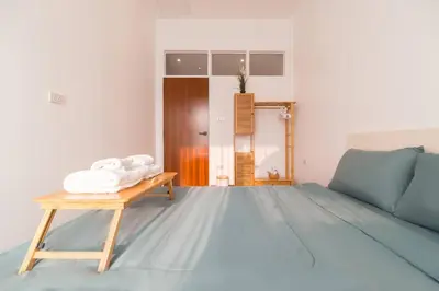 a room with a bed and a table with towels at Minimal House Maximum Happiness in Thung Maha Mek